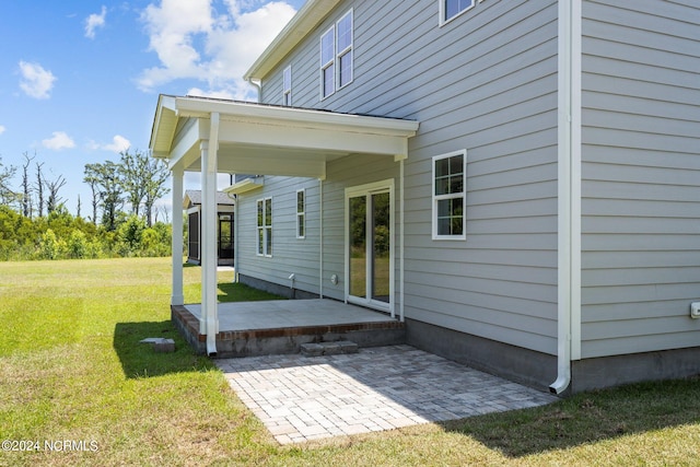 back of property with a yard and a patio