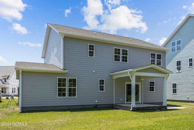 rear view of property with a lawn and a patio