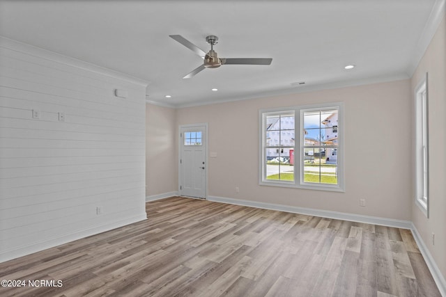 spare room with ceiling fan, ornamental molding, and light wood-type flooring