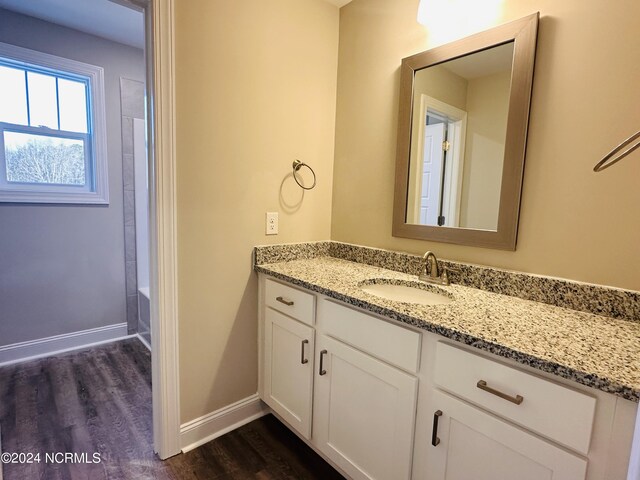 bathroom with wood-type flooring, vanity, and shower / bathtub combination