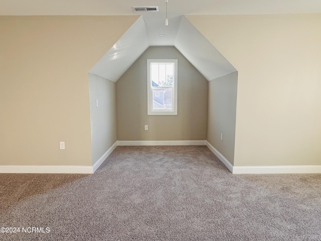 additional living space featuring vaulted ceiling and carpet