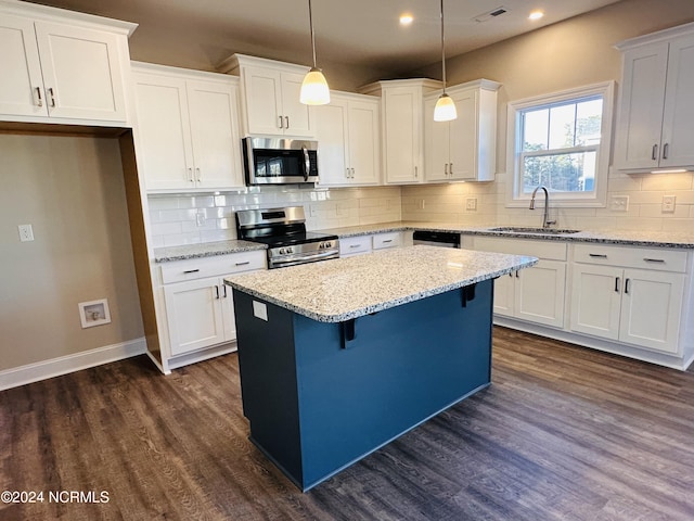 kitchen with pendant lighting, dark hardwood / wood-style floors, appliances with stainless steel finishes, sink, and tasteful backsplash