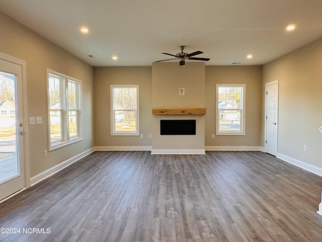 unfurnished living room featuring ceiling fan and dark hardwood / wood-style floors