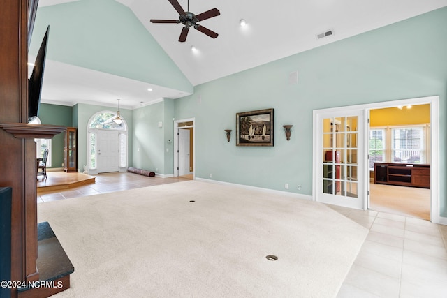 unfurnished living room with high vaulted ceiling, ceiling fan, and tile floors