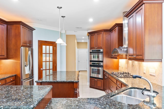 kitchen featuring appliances with stainless steel finishes, wall chimney exhaust hood, pendant lighting, sink, and tasteful backsplash