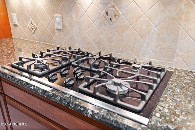 interior details featuring backsplash and stainless steel gas stovetop