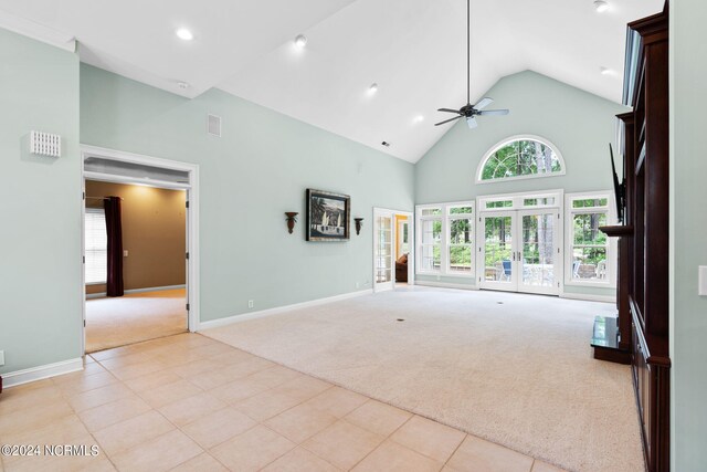 unfurnished living room featuring high vaulted ceiling, ceiling fan, and light carpet