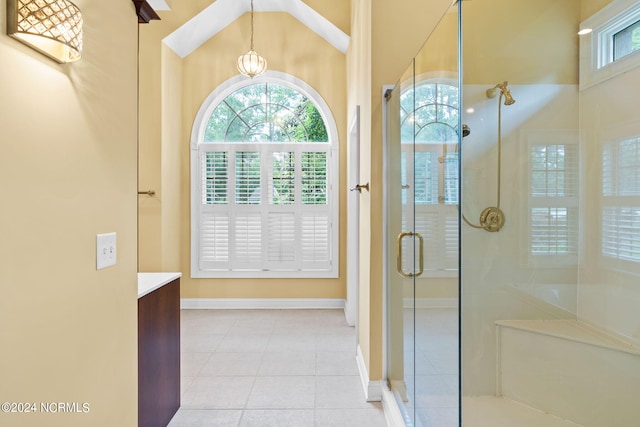 bathroom with vaulted ceiling, walk in shower, an inviting chandelier, tile floors, and vanity