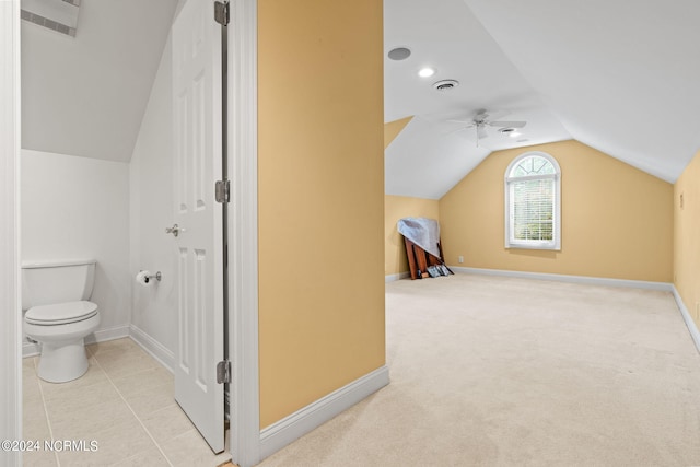 interior space featuring tile floors, ceiling fan, lofted ceiling, and toilet