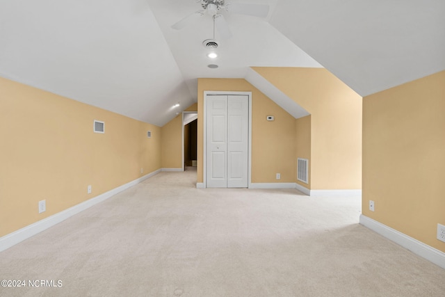 additional living space with vaulted ceiling, light carpet, and ceiling fan