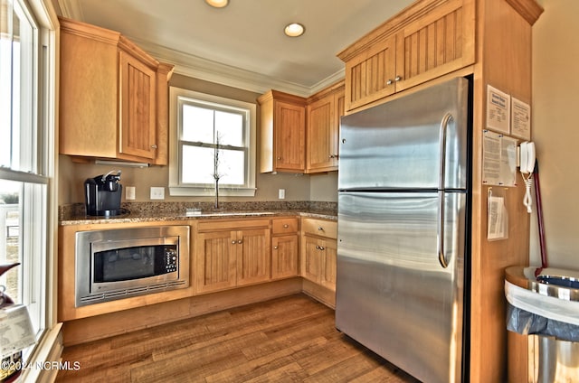 kitchen with appliances with stainless steel finishes, dark stone counters, sink, and dark hardwood / wood-style floors