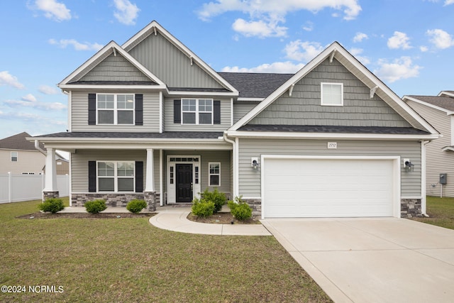 craftsman-style home with a front yard, a garage, and a porch