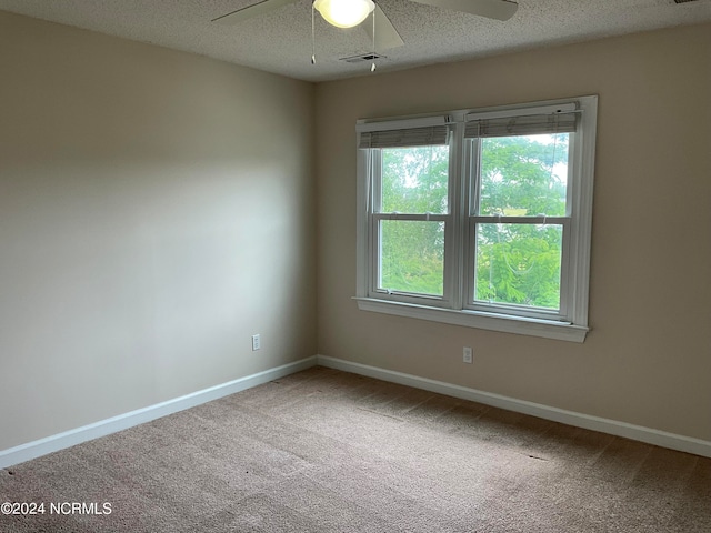 empty room featuring ceiling fan, a textured ceiling, and carpet floors