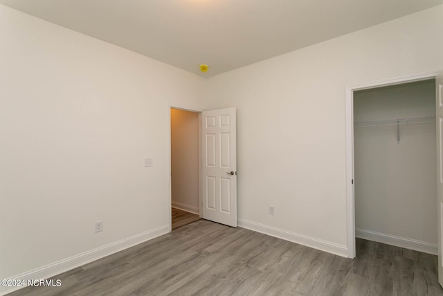 unfurnished bedroom featuring a closet and hardwood / wood-style flooring