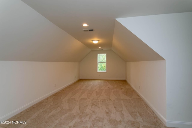 bonus room with light carpet, baseboards, visible vents, and lofted ceiling