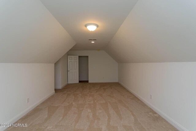 bonus room featuring light carpet and vaulted ceiling