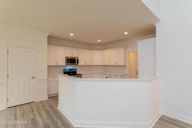 kitchen with light countertops, backsplash, appliances with stainless steel finishes, light wood-style floors, and ornamental molding