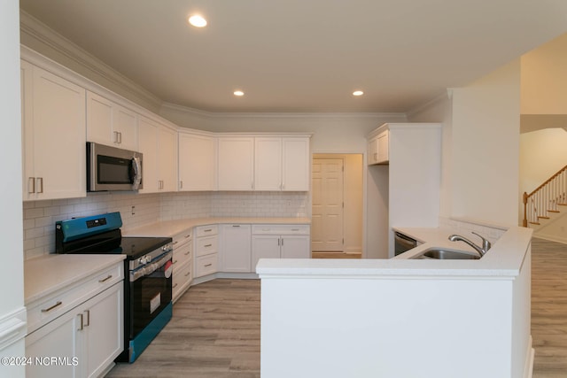 kitchen with electric stove, sink, light hardwood / wood-style floors, and backsplash