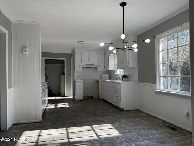 kitchen with a notable chandelier, dark wood-type flooring, white cabinets, crown molding, and decorative light fixtures