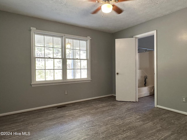 unfurnished bedroom with a textured ceiling, ceiling fan, and dark hardwood / wood-style floors