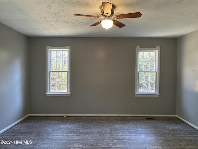 spare room featuring dark hardwood / wood-style flooring, a healthy amount of sunlight, and a textured ceiling