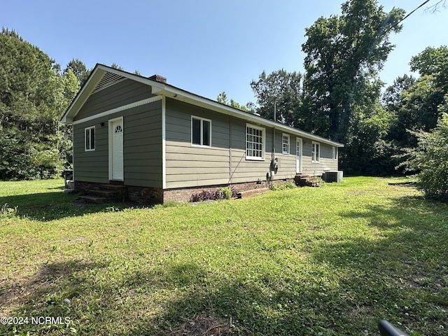 view of front of house with central AC unit and a front lawn