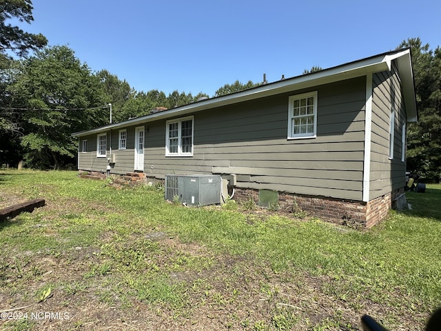 exterior space with a front lawn and central AC unit