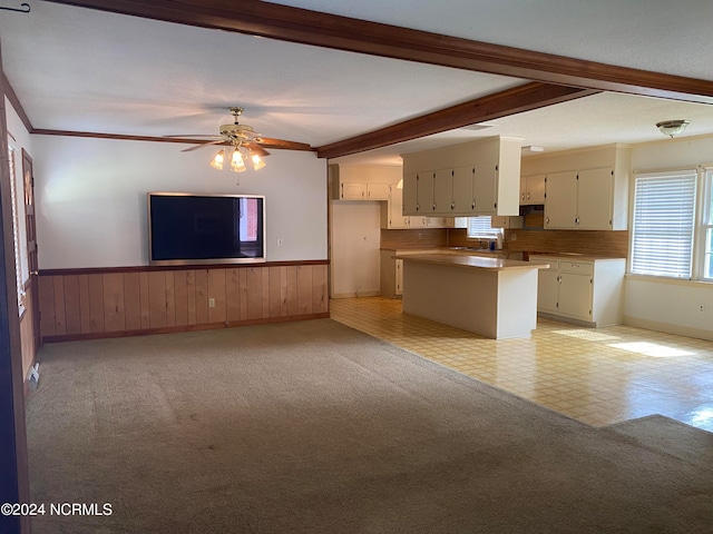 interior space with a healthy amount of sunlight, beam ceiling, ceiling fan, and light tile floors