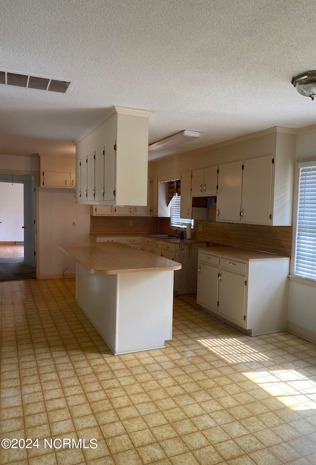 kitchen featuring light tile flooring, white cabinetry, and kitchen peninsula