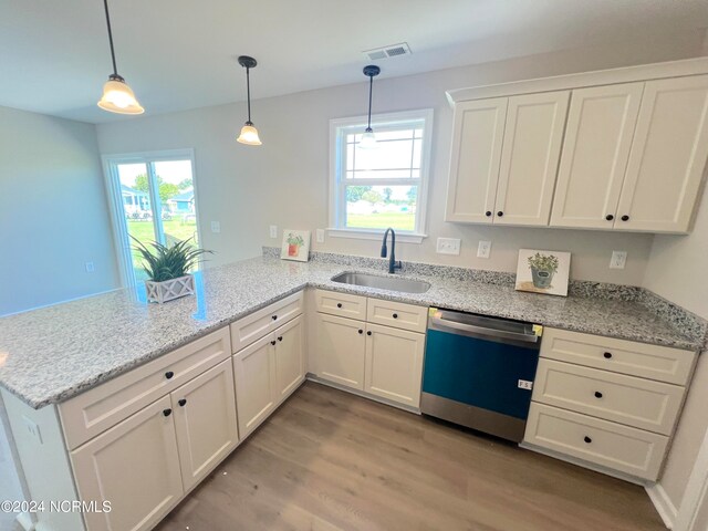 kitchen with dishwashing machine, a peninsula, a sink, visible vents, and white cabinets