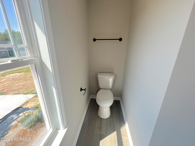 bathroom featuring baseboards, toilet, and wood finished floors