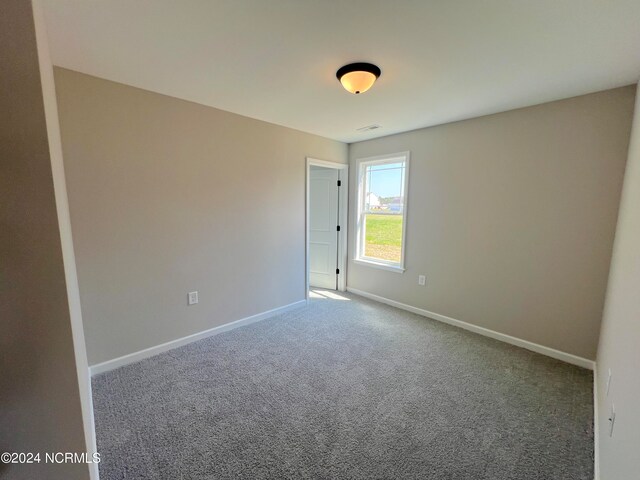 empty room featuring visible vents, baseboards, and carpet flooring