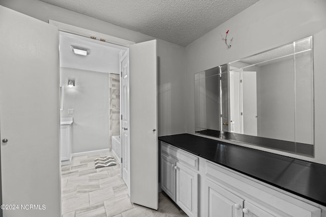 bathroom featuring a textured ceiling, vanity, and bathtub / shower combination