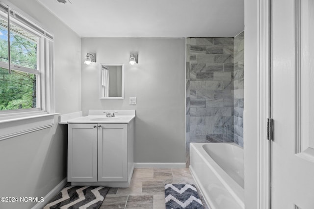 bathroom with tiled shower / bath combo and vanity