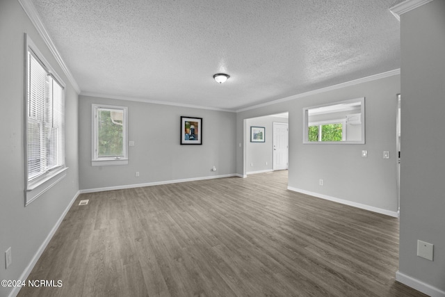 spare room with a textured ceiling, crown molding, and wood-type flooring