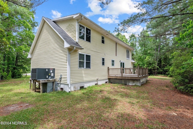 back of house featuring central AC, a lawn, and a deck