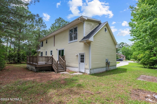 back of house featuring a wooden deck and a yard