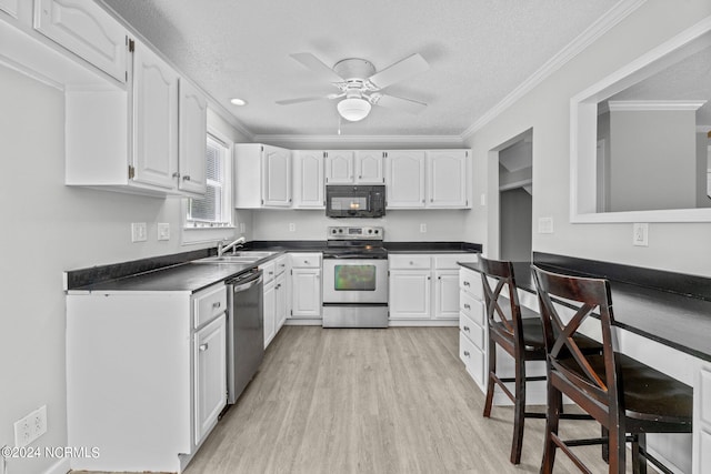 kitchen featuring appliances with stainless steel finishes, light hardwood / wood-style floors, crown molding, white cabinetry, and ceiling fan