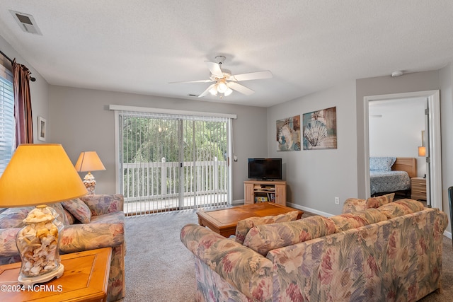 living room featuring a textured ceiling, carpet flooring, and ceiling fan