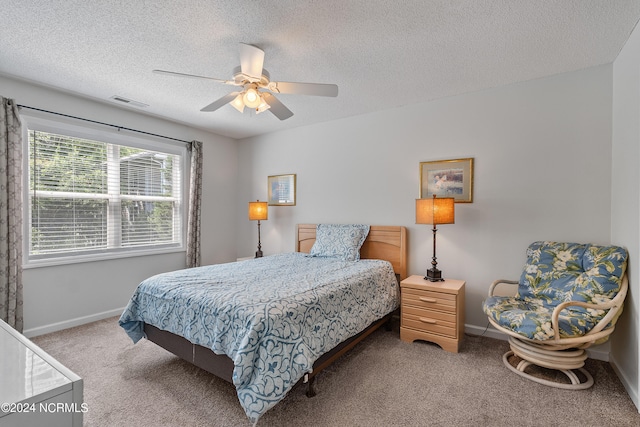 bedroom with carpet flooring, ceiling fan, and a textured ceiling