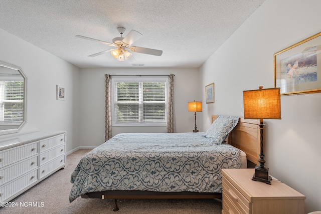 bedroom featuring a textured ceiling, carpet flooring, and ceiling fan