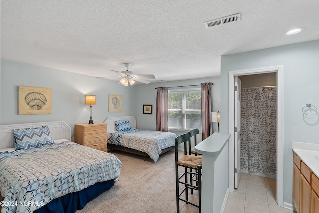 bedroom featuring ceiling fan, a textured ceiling, and light tile floors