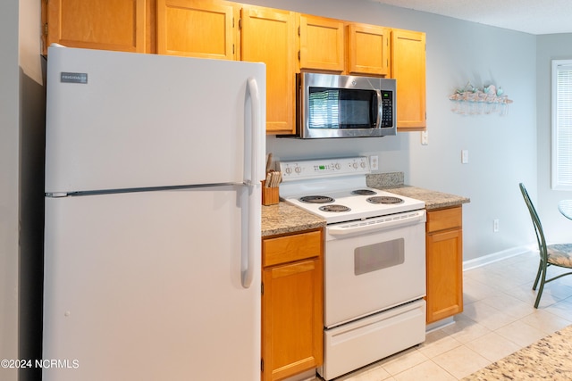 kitchen featuring white appliances and light tile floors