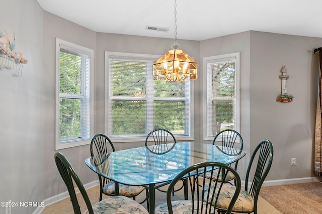 dining room featuring plenty of natural light, an inviting chandelier, and light tile floors