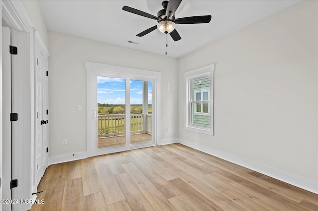 unfurnished room with light wood finished floors, baseboards, visible vents, and a ceiling fan