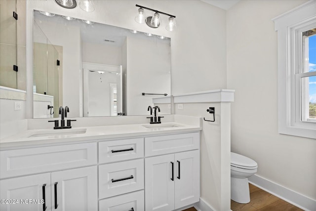 full bathroom featuring baseboards, a sink, a shower stall, and toilet