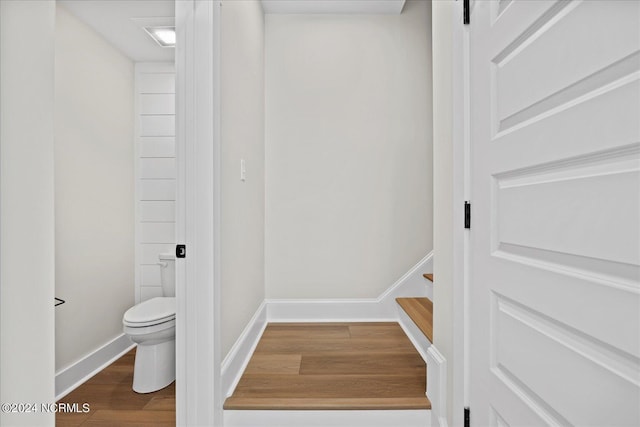 interior space with toilet, baseboards, and wood finished floors