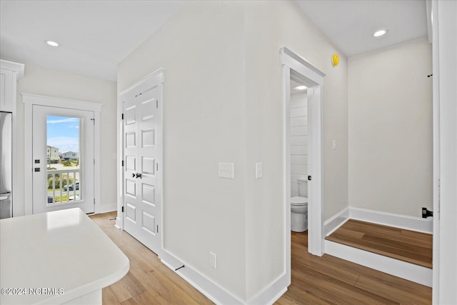 hall featuring recessed lighting, baseboards, and wood finished floors