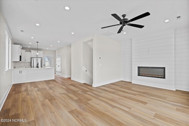 unfurnished living room with light wood-type flooring, a fireplace, and recessed lighting