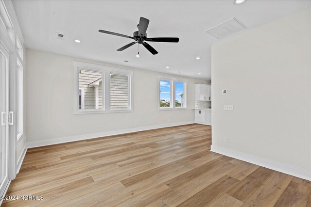 empty room with light wood finished floors, baseboards, visible vents, and recessed lighting